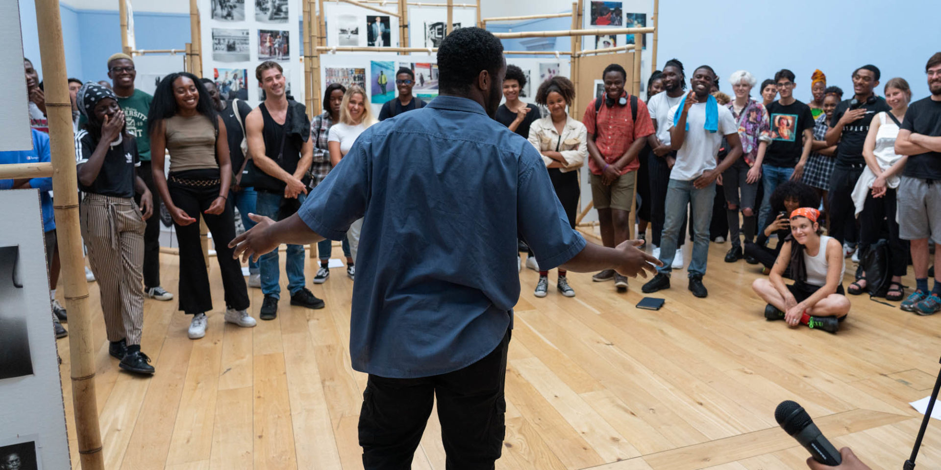 A poet stands in front of an audience of young people