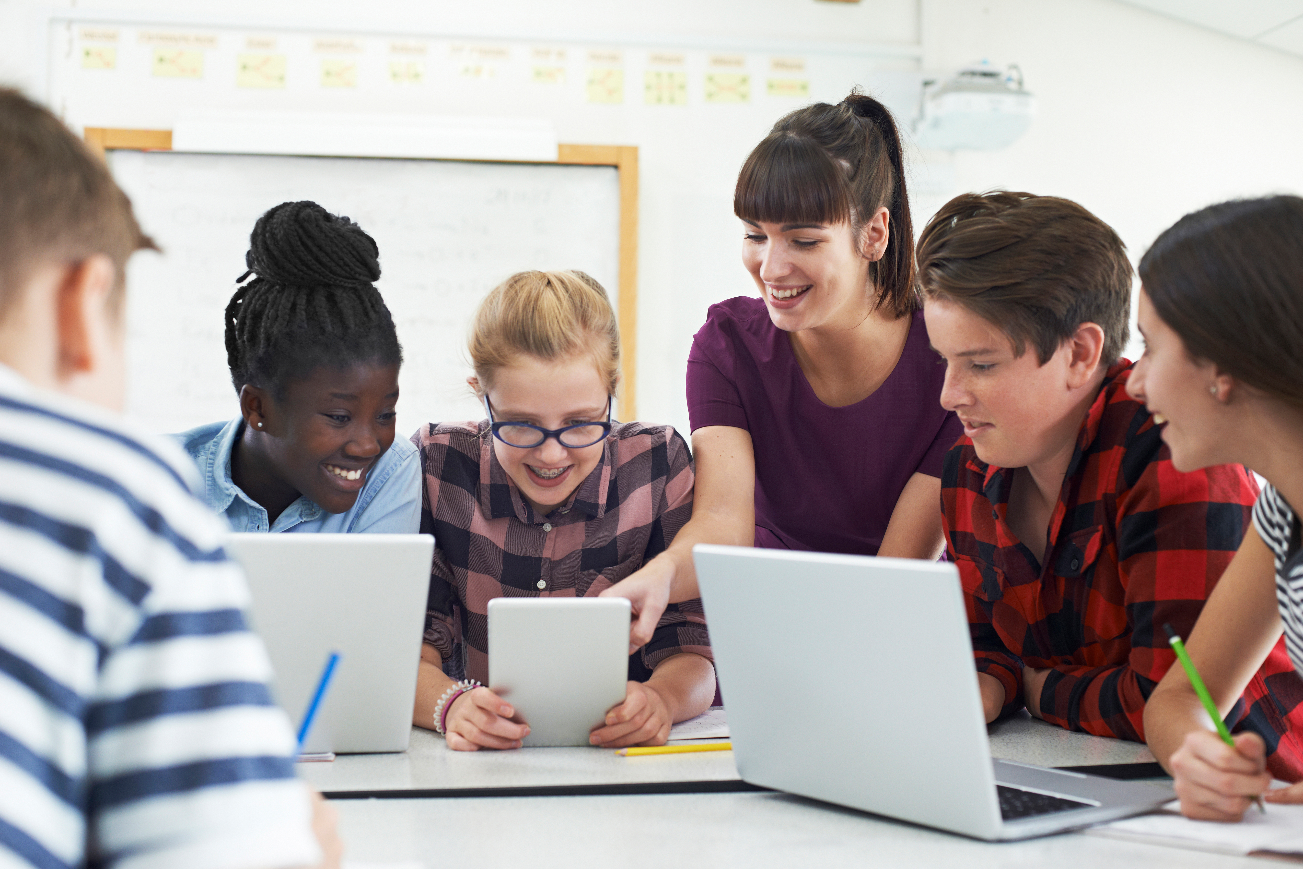 Children and teacher around laptops