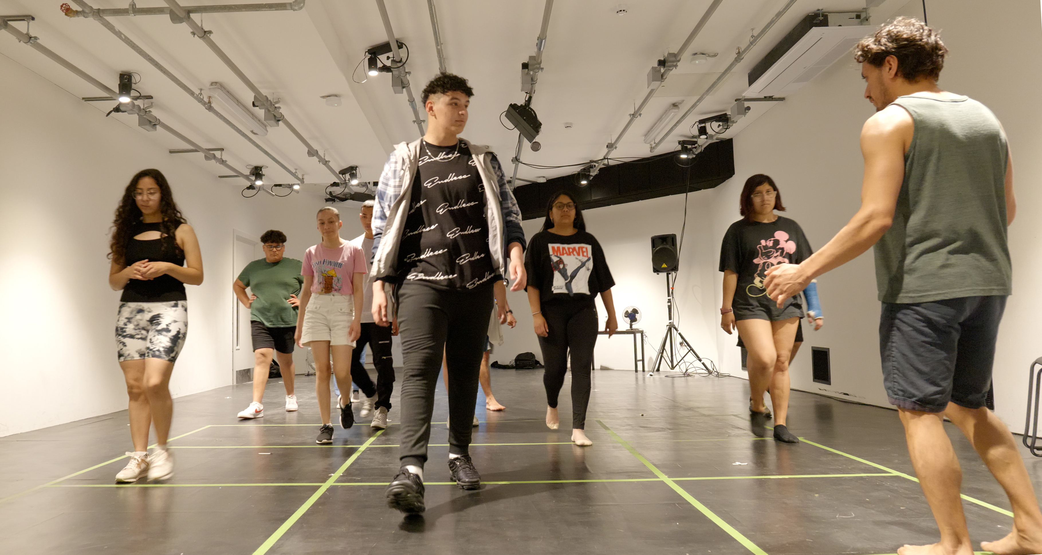 Young people walking in lines in a rehearsal room 