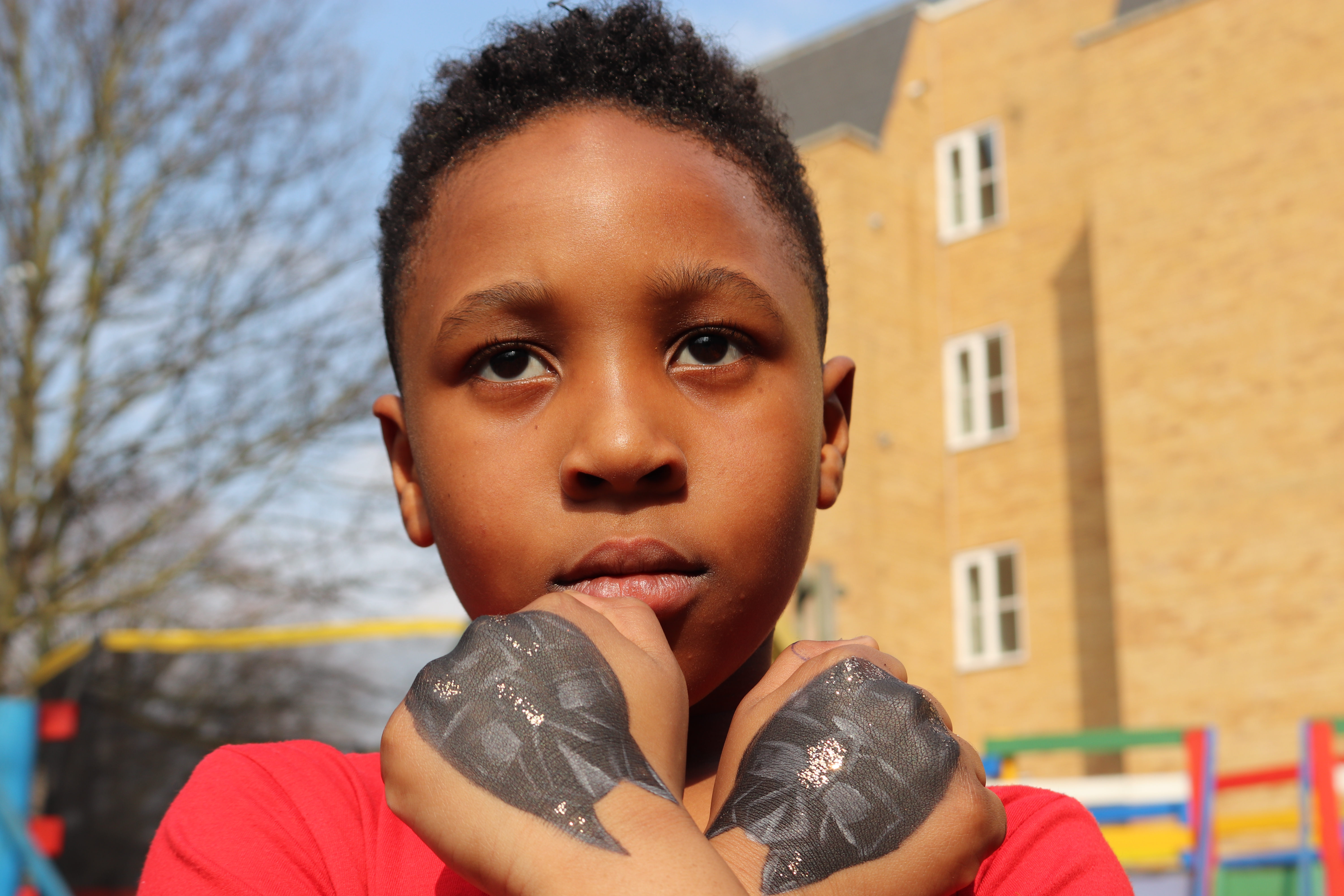 Young boy with Black Panther hands.