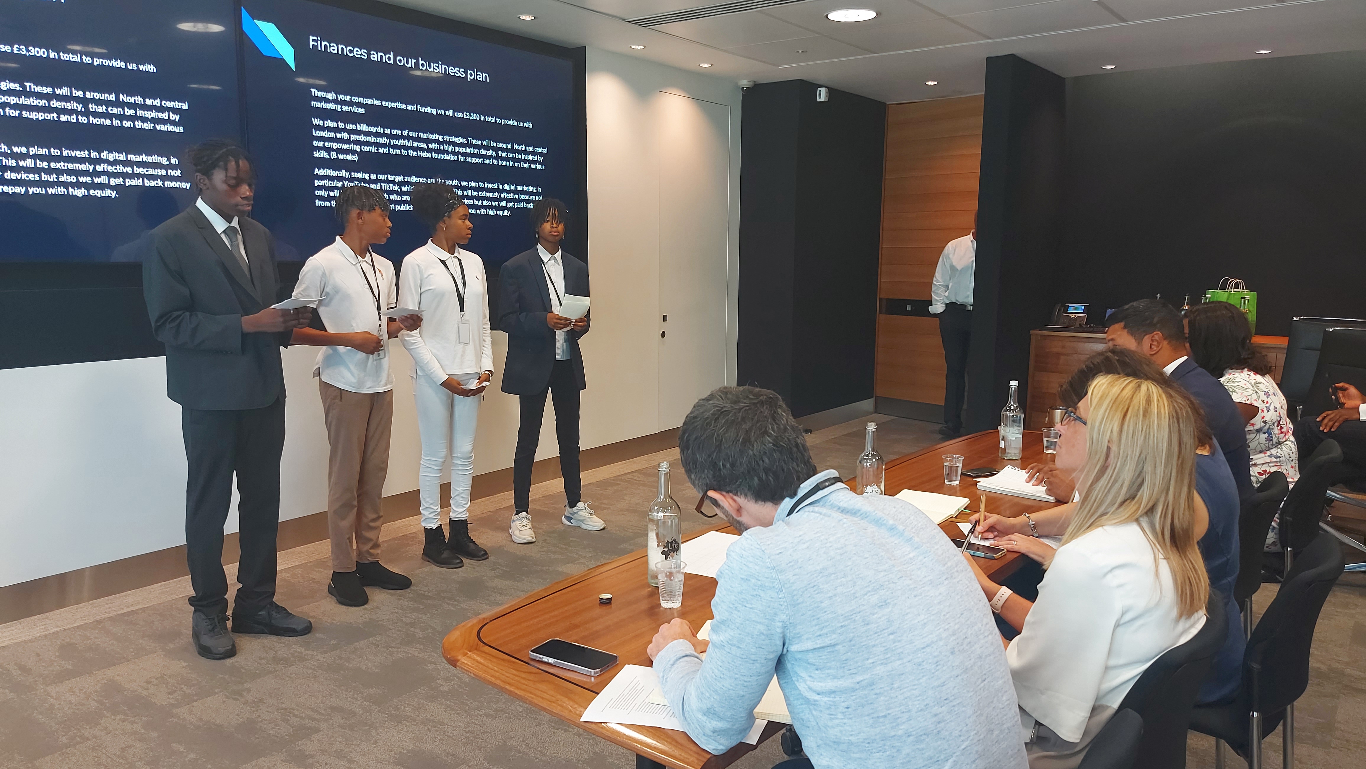 Young people giving a presentation in a boardroom